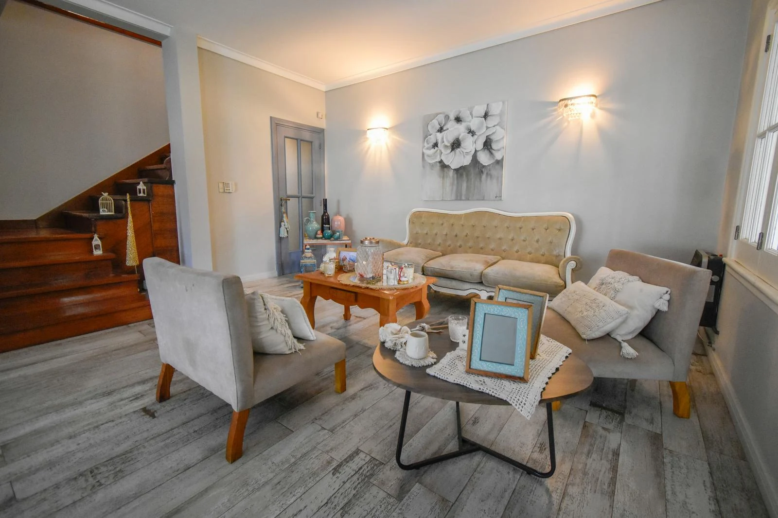 Living de la casa de Pasaje Kennedy con sillones claros y piso de madera