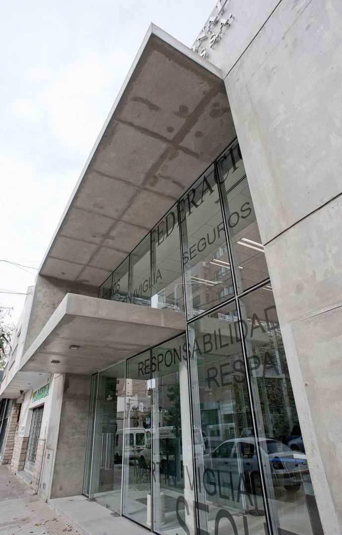 Detalle arquitectónico de Federación Patronal: voladizos de hormigón y fachada de vidrio
